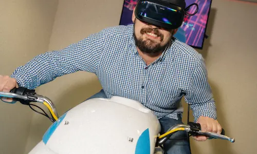 Játékos VR-headsetben a fehér VR Racing Motoron